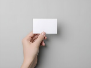Obraz premium Hand holding blank white card mockup ready for your design or message on a neutral background