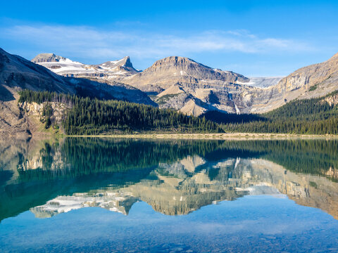  Crystal clear Bow Lake reflecting rugged mountains in Banff National Park