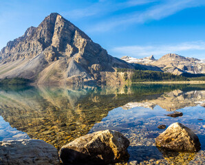  Crystal clear Bow Lake reflecting rugged mountains in Banff National Park