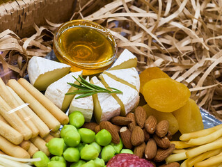 Delicious spread of cheese, fruits, nuts, and honey in a cozy picnic setting, perfect for a sunny afternoon gathering with friends