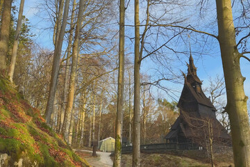 Charming wooden church nestled among tall trees in a serene forest setting, Fantoft Stave Church, the Fana borough of Bergen, Norway