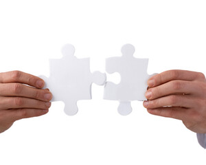Two people holding a puzzle piece together