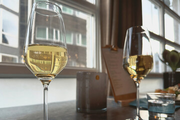 Elegant glasses of white wine on a table with a blur modern backdrop