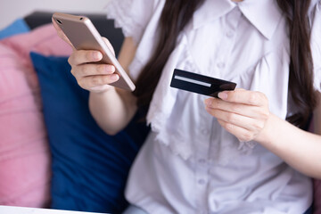 Body parts of Japanese woman online shopping by card and smartphone in the living