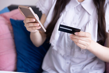 Body parts of Japanese woman online shopping by card and smartphone in the living