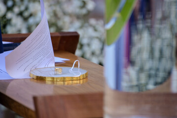wedding table setting, wedding rings on a decorative plate, ceremony vows and golden rings, a close-up of marriage symbols