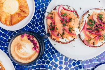 Smoked Salmon Bagels with Latte on Blue Mosaic Table
