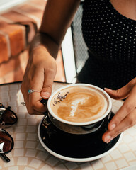 Women's Hands Holding Iced Latte with Cream Swirls