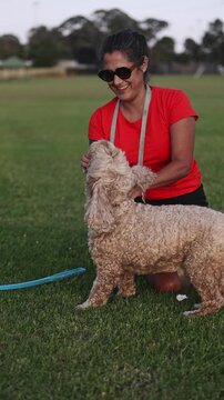Dog trainer playing with cavapoo dog in a park
