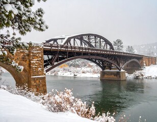 Obraz premium Steel arch bridge spans a river under a pristine blanket of fresh winter snow covered landscape