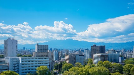 Naklejka premium Cityscape view with tall buildings, trees, and a mountain range. A bright blue sky with puffy white clouds