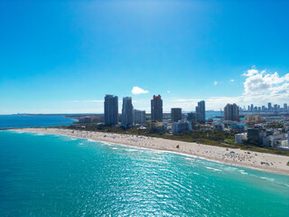 Naklejka premium Miami city landscape on blue sky with clouds. South beach coastal in Miami. Skyscrapers Miami, aerial view. South beach. Miami Beach pier. Miamis shoreline.
