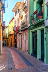Fototapeta premium Narrow street of colourfully painted houses in Villajoyosa, Costa Blanca, Spain