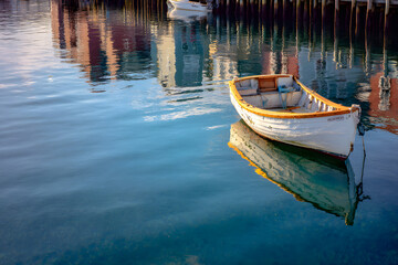 Obraz premium A tiny vessel gently resting by the tranquil harbor reflection