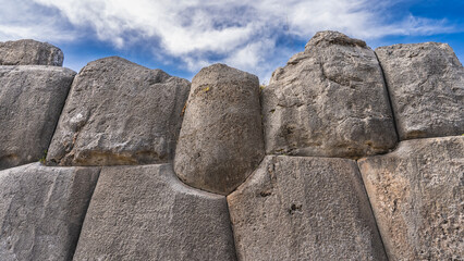 A fragment of an ancient stone wall.  Ruins of a Magnificent Inca Fortress Sacsayhuaman.  The huge boulders are tightly fitted and sanded using the Ashlar polygonal masonry technique. Peru. Cusco.
