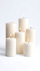 Five off-white pillar candles of varying heights are arranged on a white background, their flames flickering gently