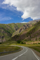 Mountain road in Altai, Russia, points directly toward snow-covered peaks. Dramatic skies and vast landscapes evoke wanderlust and connection with untouched nature.