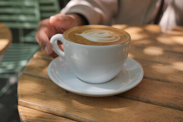 Warm cup of coffee enjoyed in sunny outdoor cafe