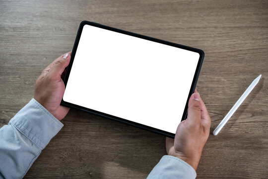 Blank screen concept represented by a person holding a digital tablet with a white display and stylus in a modern workspace, ready for content creation, design mockup, or app interface testing.