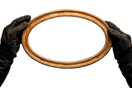 A pair of gloved hands holds a vintage wooden picture frame, ready for display or artistic creation, showcasing craftsmanship and style.