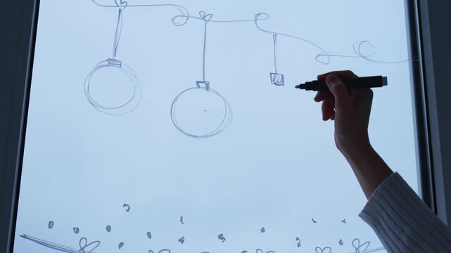 Sustainable responsible holiday decor. Female hand painting advent candles painted on window glass indoor at home. Christmas winter decoration. White pattern. Snow art tracery on season. Diy. Hygge