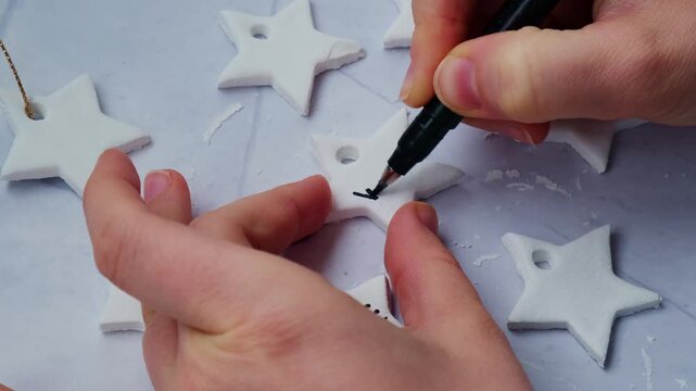 Christmas star with word WONDER Master class writing word HOPE Unrecognizable artist do it yourself air dry clay crafts for Christmas tree decor holiday. Decoration gift idea Handmade children craft