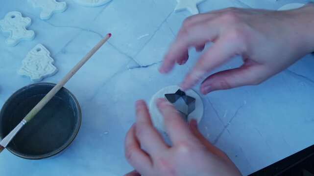 Creator is using white air dry clay for making decor to Christmas tree holiday. Creating hobby recreation activity that involves fingers. DIY crafting Modern art 
