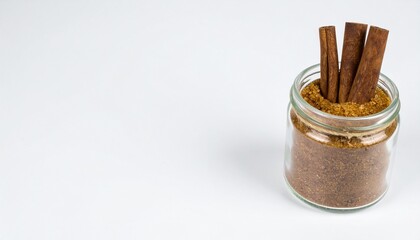 Warm spice blend of cinnamon sticks in brown sugar in a glass jar, inviting baking inspiration