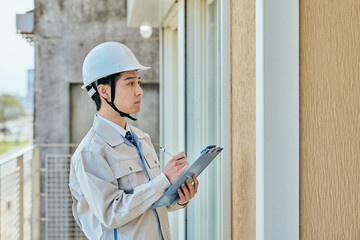 建物を確認する作業服姿の男性