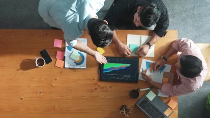 Top view of skilled project manager talking about financial graph to investors while sitting at meeting table with data analysis document. Diverse team discussing and brainstorming idea. Convocation. - Powered by Adobe