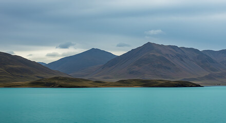 Scenic view of a turquoise lake with majestic mountains in the background