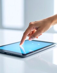 A finger touches a tablet's screen, displaying a simple interface