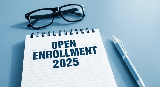 Open Enrollment 2025 on Notepad with Pen and Glasses for Planning and Preparation on Blue Table
