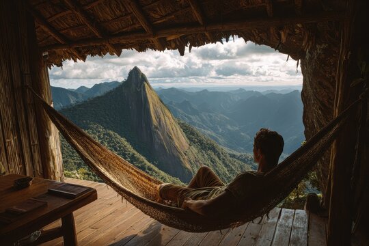 Hammock Mountains. Young Man Relaxing in Hammock in Mountain Cabin - Powered by Adobe