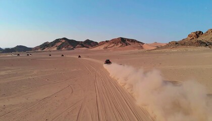 Several vehicles drive across a sandy desert landscape, creating trails of dust.