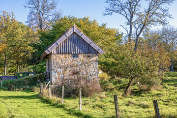 Obraz premium Old mill barn in a rural sunny meadow landscape