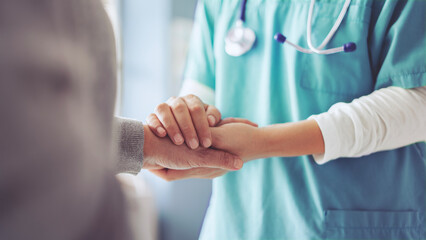 Hands holding old woman's hands