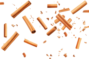 Falling cinnamon sticks create a dynamic display against a transparent background showcasing their rich texture and warm color