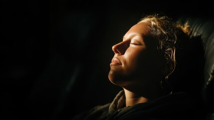 At-home workouts concept shows A serene woman with closed eyes, illuminated by soft light, conveying peace and tranquility.