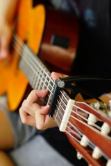 Fototapeta premium close-up shots of hands playing the guitar, showcasing different finger positions and techniques, perfect for music enthusiasts and instructional content