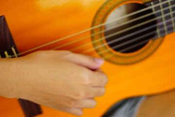 Fototapeta premium close-up shots of hands playing the guitar, showcasing different finger positions and techniques, perfect for music enthusiasts and instructional content