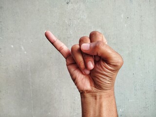 A hand gesture of a little finger held up, a common sign for a "pinky promise" or "pinky swear." The gesture symbolizes a solemn vow, a promise that is not to be broken.