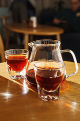 Enjoying Alternative Brewed Coffee in Transparent Cups on Wooden Table at Sunlit Cafe