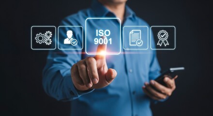 Man in blue shirt interacting with iso icons on a screen with his finger and holding a smartphone device