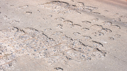 The old damaged road background with worn and broken texture on concrete street surface, The reinforcing steel wire mesh is visible.