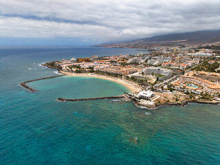 Fototapeta premium Sandy beach, city and mountains in the background, Canary Islands, aerial view