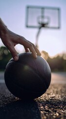 Fototapeta premium Hand holding a basketball on an outdoor court, preparing for a game under soft autumn light. Generated image