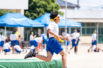 中学校の体育祭でリレーを走る男子生徒