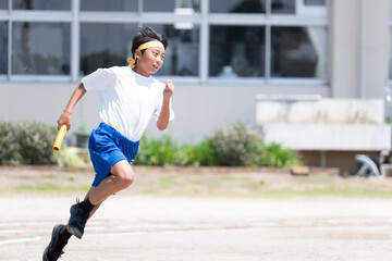 中学校の体育祭でリレーを走る男子生徒