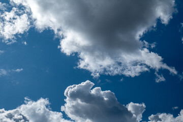 Obraz premium Fluffy White Clouds Floating Across a Vibrant Blue Sky